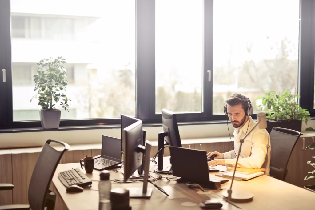Hire Act: How a 25% Outsourcing Tax Could Disrupt US Tech & India’s $280B IT Services Industry 2 man with headphones facing computer monitor